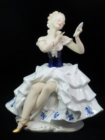 WALLENDORF FIGURE OF WOMAN PUTTING ON MAKEUP: large figurine of a seated woman putting on makeup. from Wallendorf, Germany. Her skin has a matte finish, while her white dress trimmed in cobalt blue has a glazed finish. The bottom has Wallendorf l