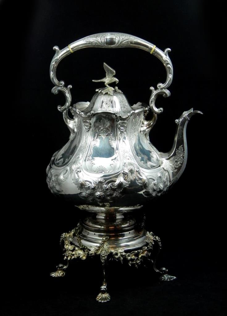 ANTIQUE ENGLISH SILVER PLATE TEA KETTLE w WARMER: Antique English silver plate tea kettle having a scrolled repousse design throughout. Rests on fitted warmer. Figural bird finial to cover. Circa 19th century. Measures approx. 17 1/4" height. Total w