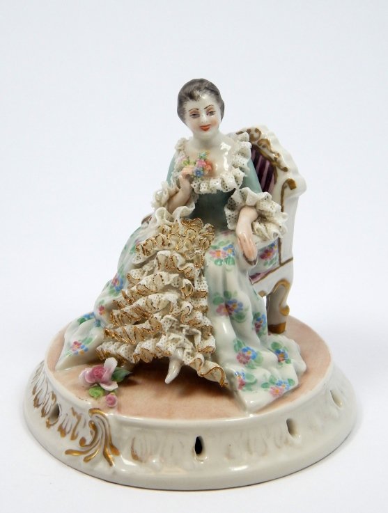 ANTIQUE DRESDEN LACE PORCELAIN FIGURE OF WOMAN: Antique Dresden German lace porcelain sculpture depicting a woman seated on a chair. Bottom holds blue five point crown over N mark. Circa late 19th century to early 20th century. Measures approx. 4 3