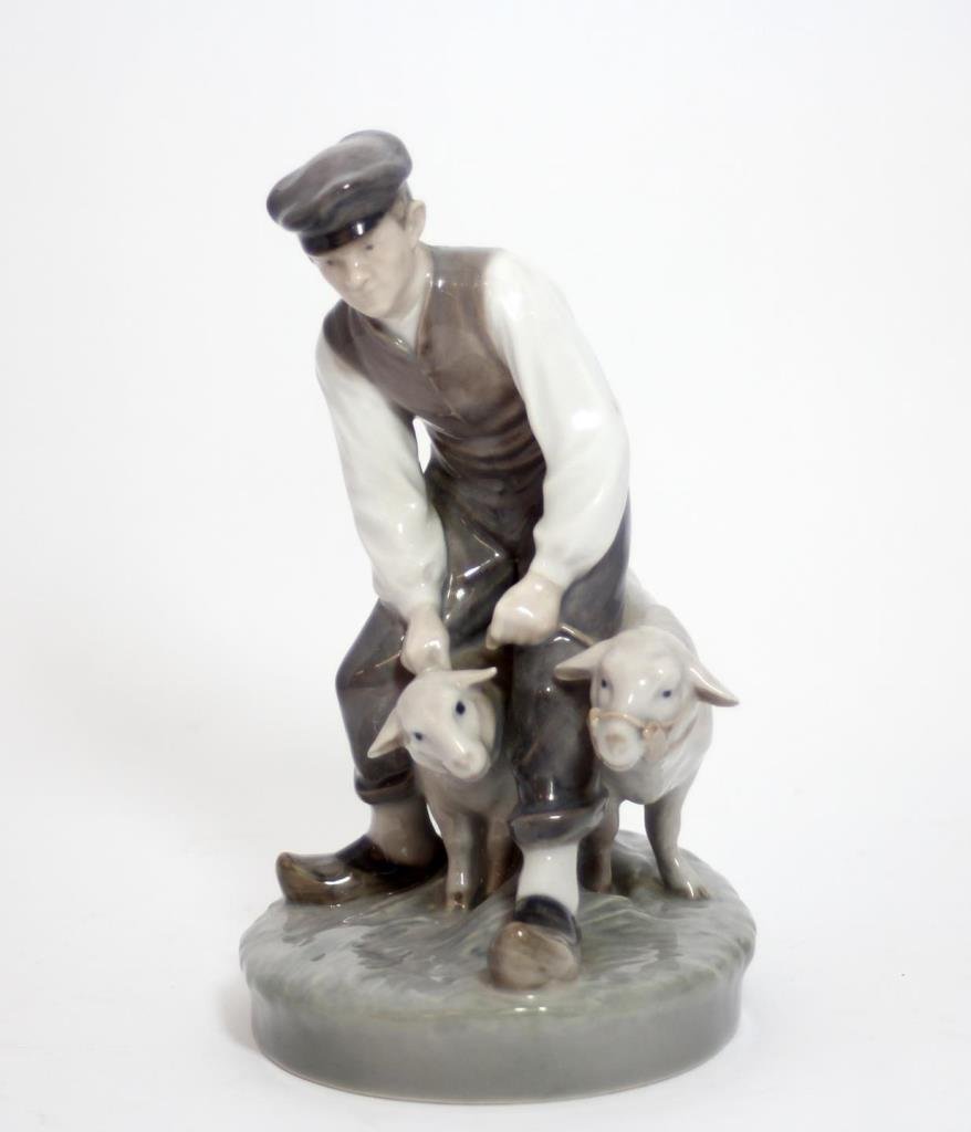ROYAL COPENHAGEN PORCELAIN SHEPHERD FIGURE #627: Royal Copenhagen Danish porcelain figure depicting a man with two lambs. Marked to bottom and numbered 627. Has 'dh' painter's initials. Circa the second quarter of the 20th century. Measures approx.