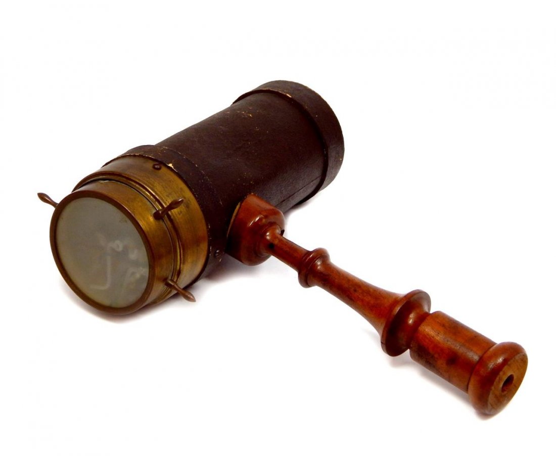 ANTIQUE LEATHER, BRASS AND WOOD KALEIDOSCOPE: Antique kaleidoscope crafted of leather, wood and brass. 19th century. Measures approx. 10" length x 12" height.