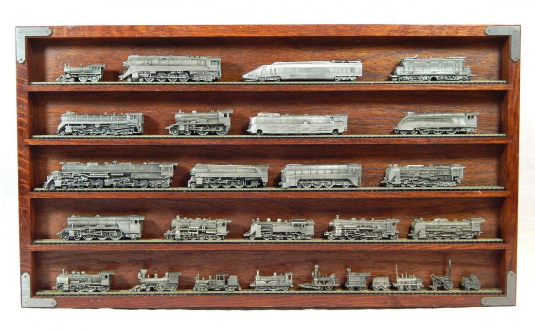 27pc FRANKLIN MINT 'WORLDS GREATEST LOCOMOTIVES': A 27 piece Franklin Mint 'The World's Greatest Locomotives' pewter train set. Includes wooden wall display plaque with train tracks. Also includes certificates of authenticity with certificate box. Me