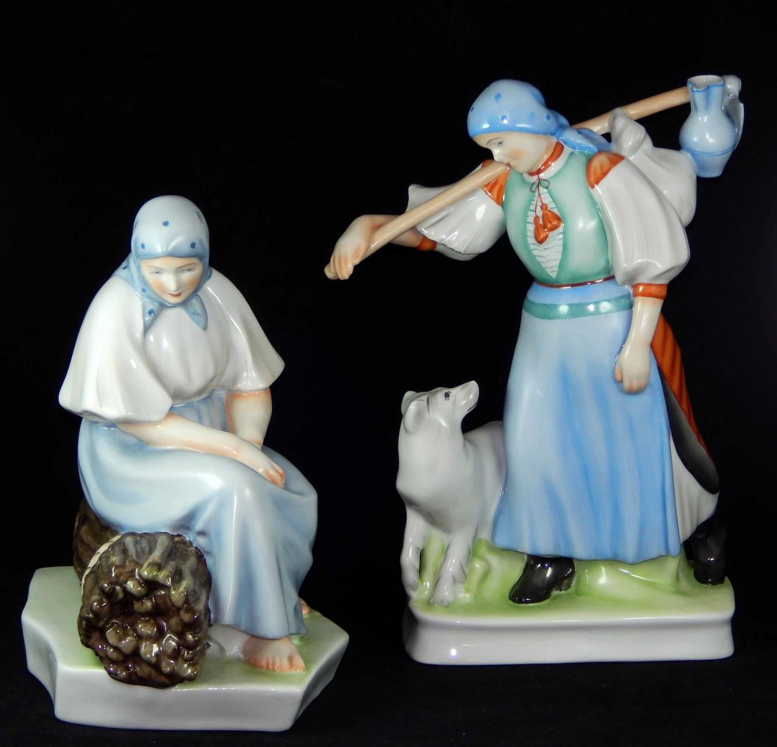 (2) LARGE ZSOLNAY HUNGARY PORCELAIN STATUES: (2) LARGE ZSOLNAY HUNGARY PORCELAIN STATUES. MEASURES: WOMEN W/ DOG-13" X 13 1/12" & WOMEN SITTING ON LOGS- 12" X 11", TOTAL LOT WEIGHT: 3.9kg