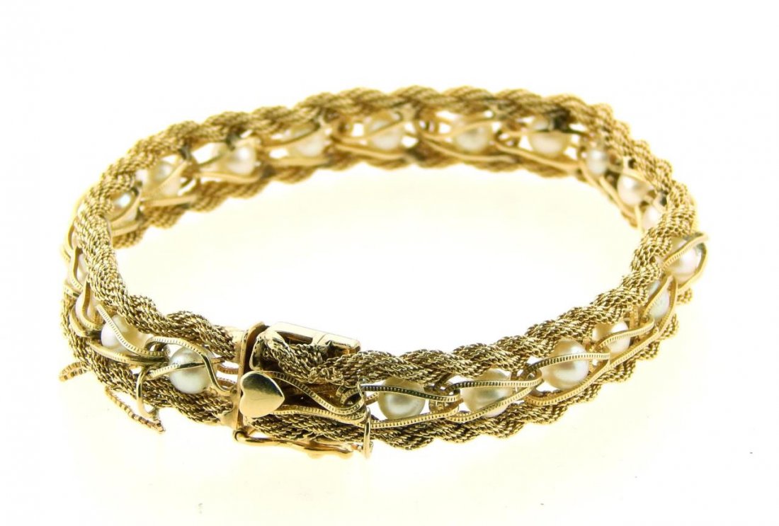 14K YELLOW GOLD AND PEARL ROPE BRACELET: A fabulous ladies 14k yellow gold rope design bracelet featuring 21 round sea pearls. Box safety chain. Impressed '14K' to clasp. Measures approx. 7 3/4" length. Approx. 11mm - 12mm width. Total weigh