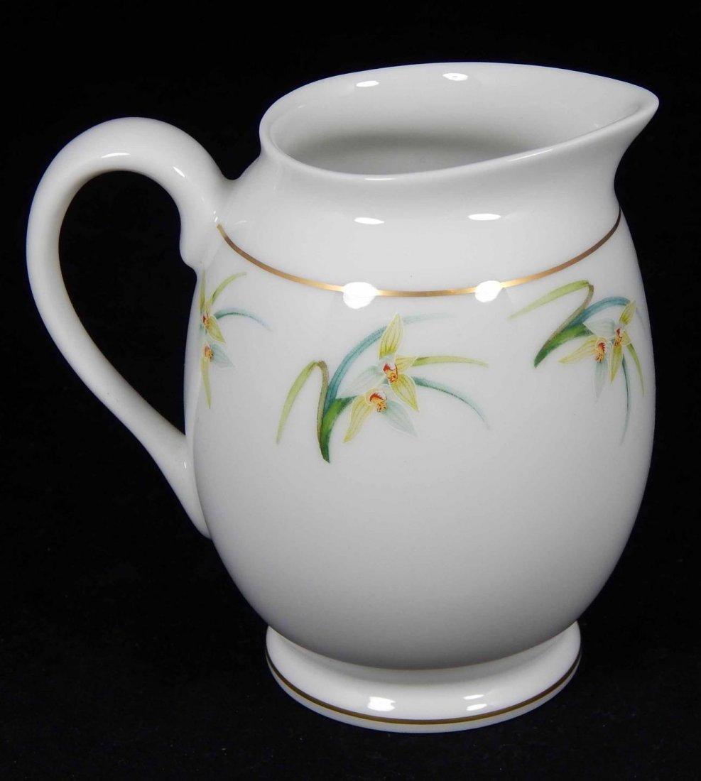 LALIQUE FRENCH PORCELAIN ORCHIDEES CREAMER: Lalique French Limoges porcelain 'Orchidees' pattern creamer with floral design. Includes box. Creamer measures 4" height. Total weight 370 grams.