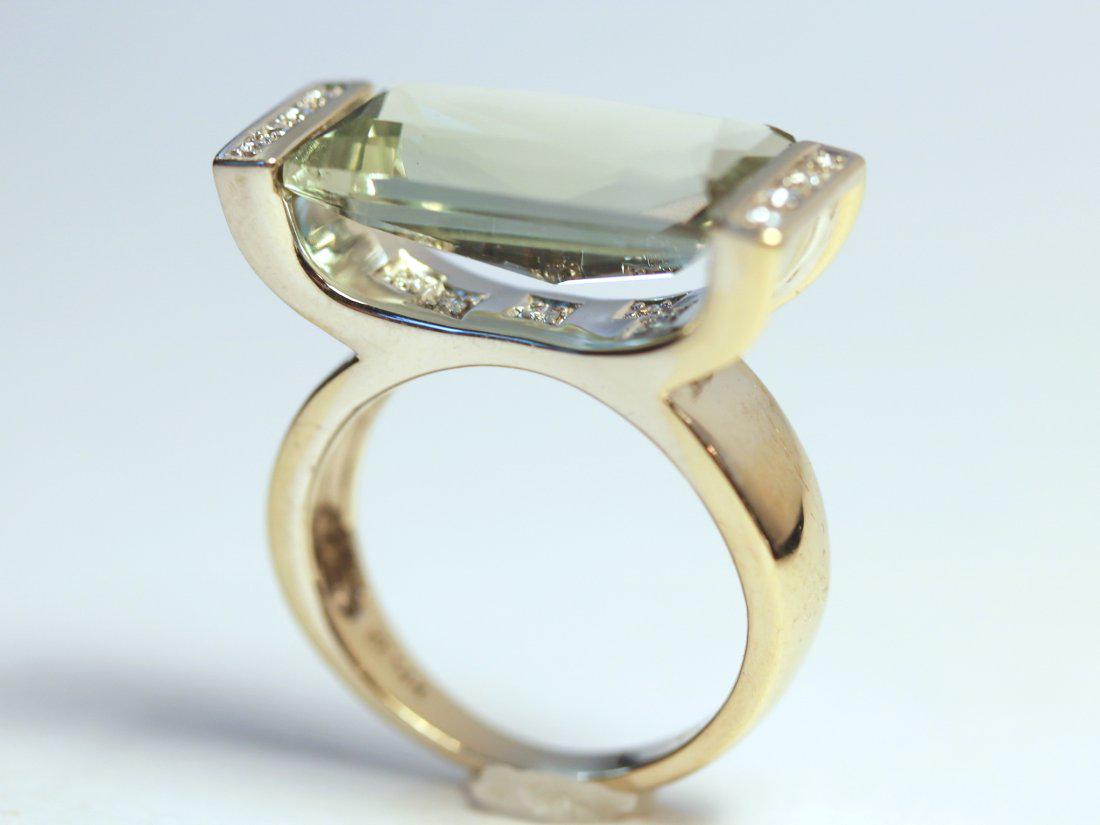 Prasiolite Quartz & Diamond 14K White Gold Ring: 14k white gold ring with prasiolite (green) quartz set horizontally secured by a raised curved bar. Four bead set, round brilliant cut diamonds are set at the ends of the bar. TW of Colored Stone: 8.3