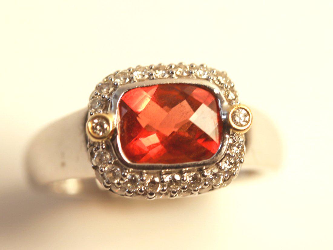 14K White Gold Orange Topaz and Diamond Ring: 14K white gold ring featuring a bezel set orange topaz and accented with a yellow gold bezel set with forty round brilliant cut diamonds. TW of Colored Stone: 0.78ct TW of Diamonds: 0.42ct TW of Ring: