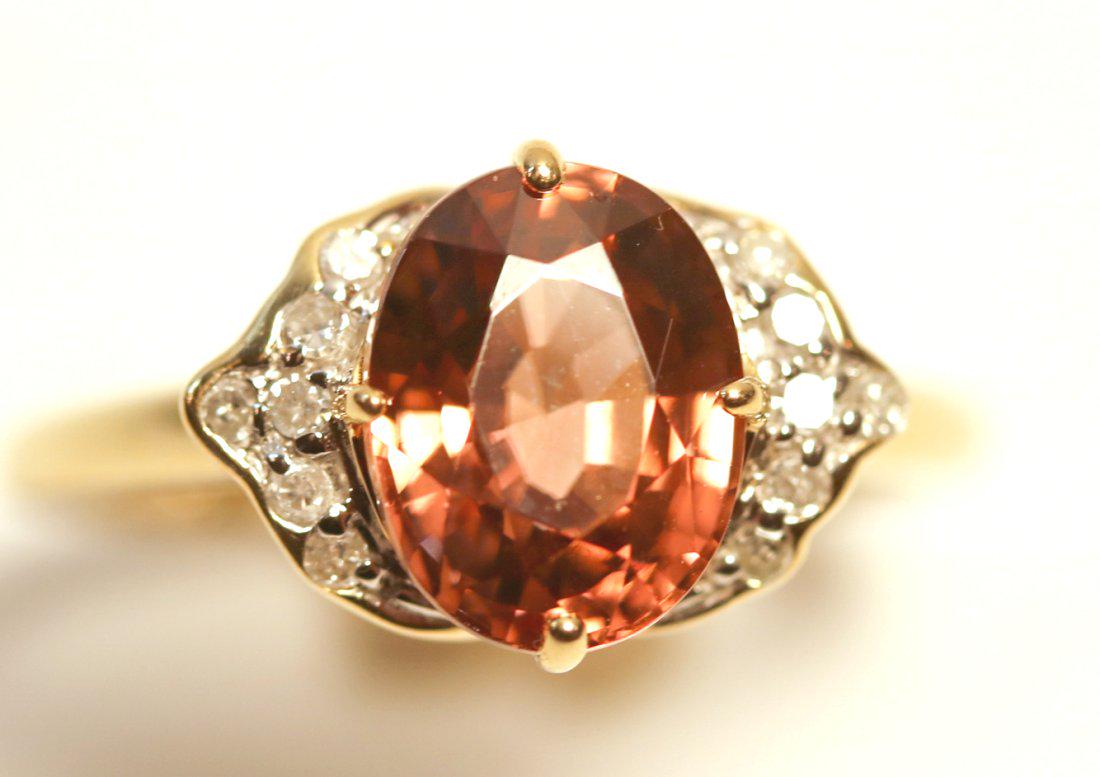 Peach Zircon & Diamond 14K Yellow Gold Ring: 14kt yellow gold ring featuring a zircon gemstone accented by twelve, bead set, round brilliant cut diamonds. TW of Colored Stone: 2.72ct TW of Diamonds: 0.07ct TW of Ring: 2.42gm Size: 6 TW and sizes