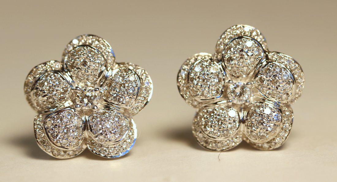 Floral Motif 14K White Gold Earrings with Diamonds: 14k white gold floral motif earrings. Each earring features 90 pave set, round brilliant cut diamonds and a center, round brilliant cut diamond. A total of one hundred-eighty-two diamonds. Omega clip 