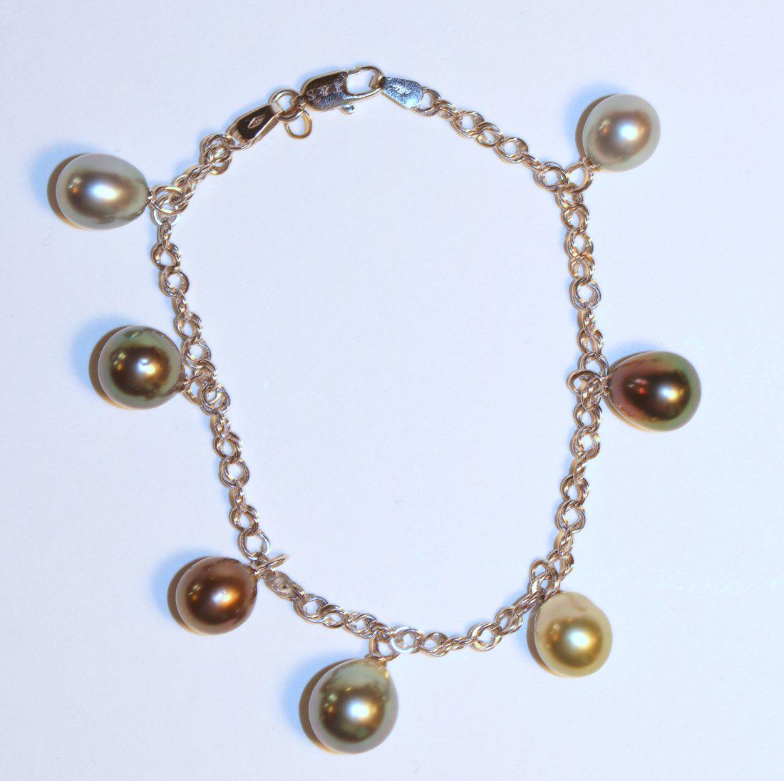 18K White Gold Tahitian Pearl Bracelet: 18k white gold bracelet with seven, evenly spaced, drop Tahitian pearls. Pearls measure 8.5mm to 11.0mm in size, silver, black, pistachio, and gray in color. Very good luster, drop shape, mostly clean