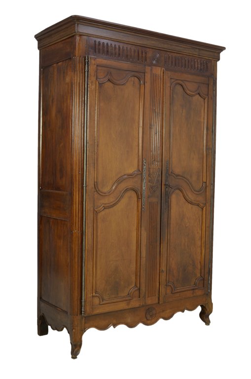 A TALL ANTIQUE LOUIS XVI STYLE WALNUT ARMOIRE WITH SUN: A TALL ANTIQUE LOUIS XVI STYLE WALNUT ARMOIRE WITH SUN Late 19th - Early 20th Century A fine Louis XVI style antique walnut armoire features a stepped cornice, having two carved panel doors, a shaped 