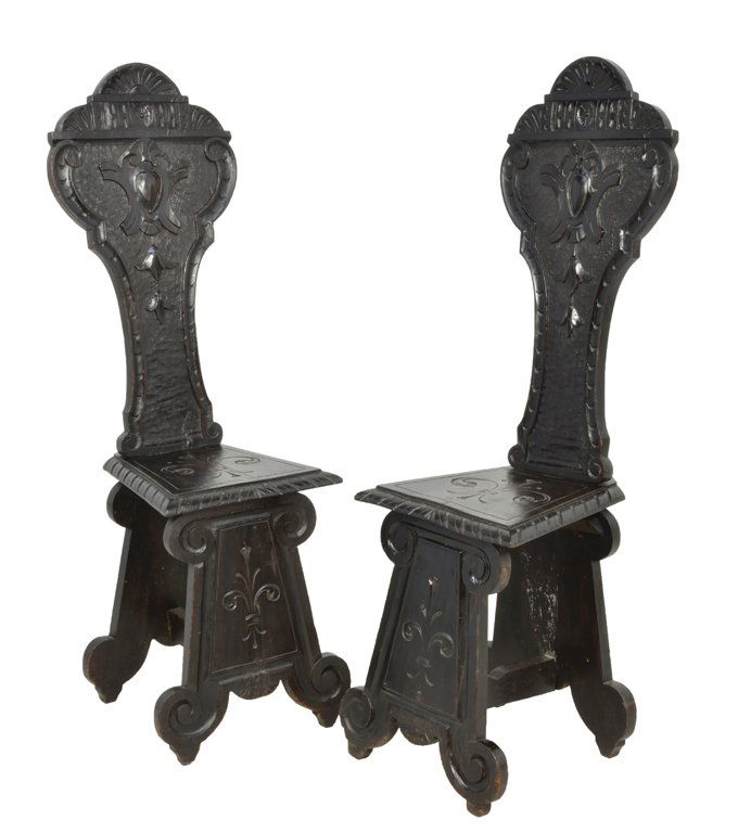 A PAIR OF RENAISSANCE REVIVAL STYLE CARVED AND EBONIZED: A PAIR OF RENAISSANCE REVIVAL STYLE CARVED AND EBONIZED WALNUT STOOL CHAIRS 19th Century, Italy A pair of Renaissance Revival style carved chairs are ebonized having a key shaped back with trefoil sha