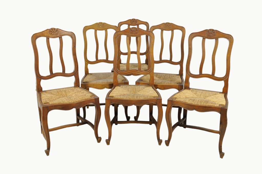 A SET OF SIX FRENCH PROVINCIAL STYLE WALNUT DINING CHAI: A SET OF SIX FRENCH PROVINCIAL STYLE WALNUT DINING CHAIRS Early 20th Century, France Each chair with an arched crest rail featuring a carved shell motif above an open shaped back is supported by an in