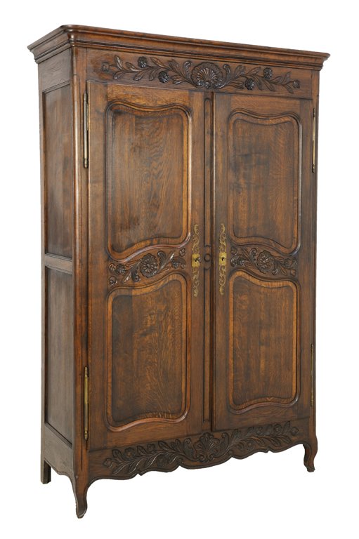 AN ANTIQUE LOUIS XV STYLE ARMOIRE: AN ANTIQUE LOUIS XV STYLE ARMOIRE Early 20th Century The rectilinear cornice surmounts a recessed, conforming body housing interior shelving with carved details at frieze above two locking doors with 