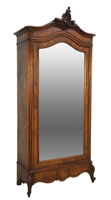 A LOUIS XV STYLE ARMOIRE: A LOUIS XV STYLE ARMOIRE 20th Century An intricately carved cornice featuring scroll work details above a recessed, conforming body with chevron details and locking door highlighted by shaped, beveled
