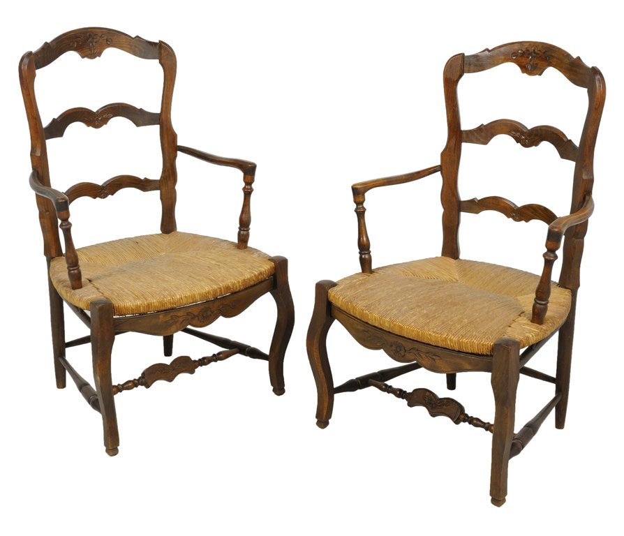 A PAIR OF FRENCH PROVENCAL STYLE LADDER BACK RUSH SEAT : A PAIR OF FRENCH PROVENCAL STYLE LADDER BACK RUSH SEAT ARMCHAIRS Late 19th-Early 20th Century A pair of French Provencal style ladder back arm chairs feature a center carved flower detail on arching c