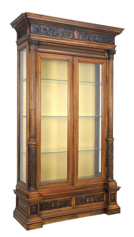 A LARGE WALNUT DISPLAY CABINET Early 20th Century Very : A LARGE WALNUT DISPLAY CABINET Early 20th Century A rectilinear, stepped cornice above an ebonized and carved frieze featuring red crest surmounting display cabinet with locking doors flanked by carve