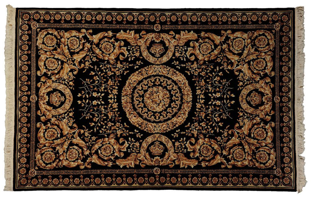 A HAND WOVEN BLACK AND GOLD VERSACE DESIGN RUG