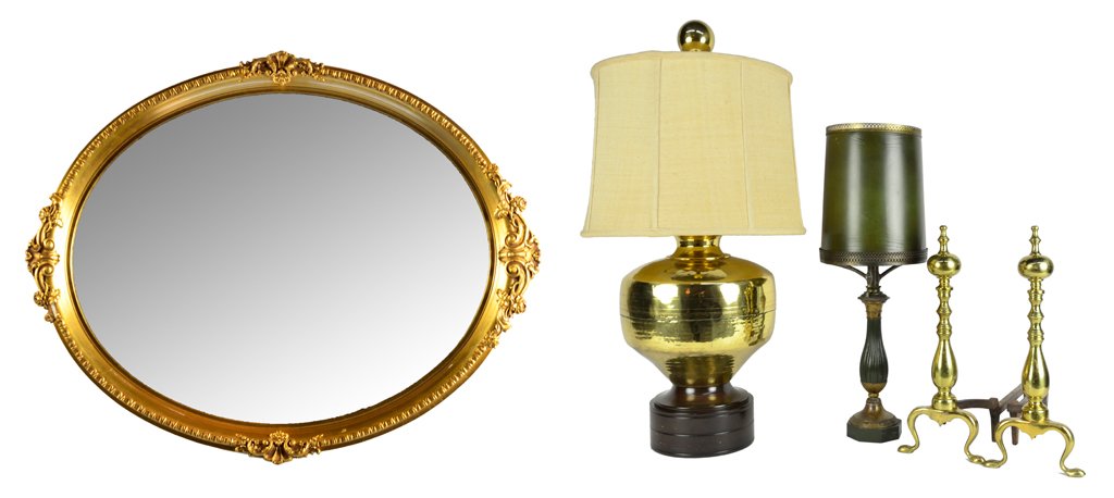 A VINTAGE COLLECTION OF LAMPS, ANDIRONS AND A MIRROR: A VINTAGE COLLECTION OF LAMPS, ANDIRONS AND A MIRROR Mid-20th Century Includes an oval giltwood mirror, two lamps and a pair of brass andirons. 38½ x 13½ x 13½ inches Five pieces total.