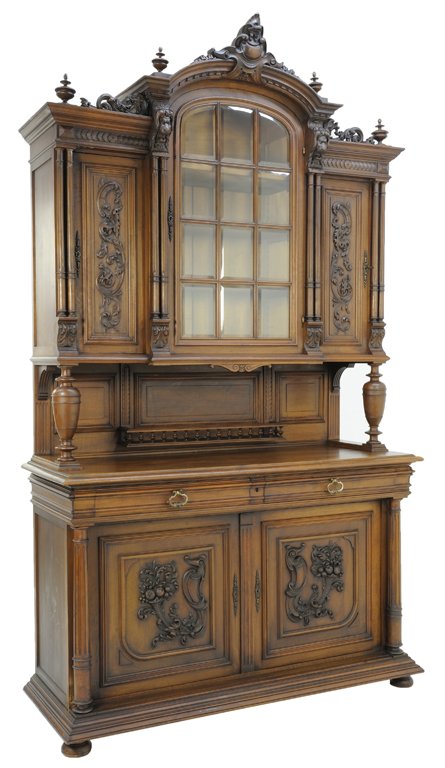 A HENRI II STYLE WALNUT BUFFET WITH LION AND FRUIT: A HENRI II STYLE WALNUT BUFFET WITH LION AND FRUIT Early 20th Century A Henri II style buffet with foliate carved cornice features two panel doors with carved foliate detail, a center glazed panel doo