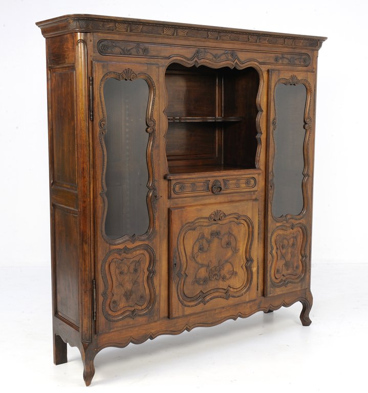 AN ANTIQUE FRENCH PROVENCAL LOUIS XV STYLE OAK SHOWCASE: AN ANTIQUE FRENCH PROVENCAL LOUIS XV STYLE OAK SHOWCASE CABINET Early-Mid-20th Century, France An antique French Provencal Louis XV style cabinet features a stepped cornice, with center open shelf, dr