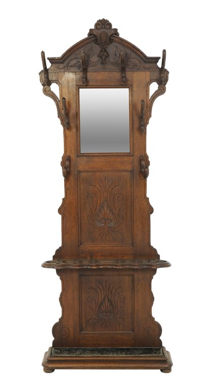 A VICTORIAN COAT RACK WITH IVY DETAILS: A VICTORIAN COAT RACK WITH IVY DETAILS 20th Century A Victorian style coat rack features an arching pediment with shield medallion, wooden hooks, with carved ivy details, a cane/umbrella holder, on a