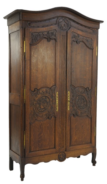 A LOUIS XV NORMAN STYLE ARMOIRE WITH DOVE AND EAGLE: A LOUIS XV NORMAN STYLE ARMOIRE WITH DOVE AND EAGLE Late 19th Century, France A Louis XV Norman style armoire with arched cornice, a medallion with dove frieze, having conforming doors featuring eagle