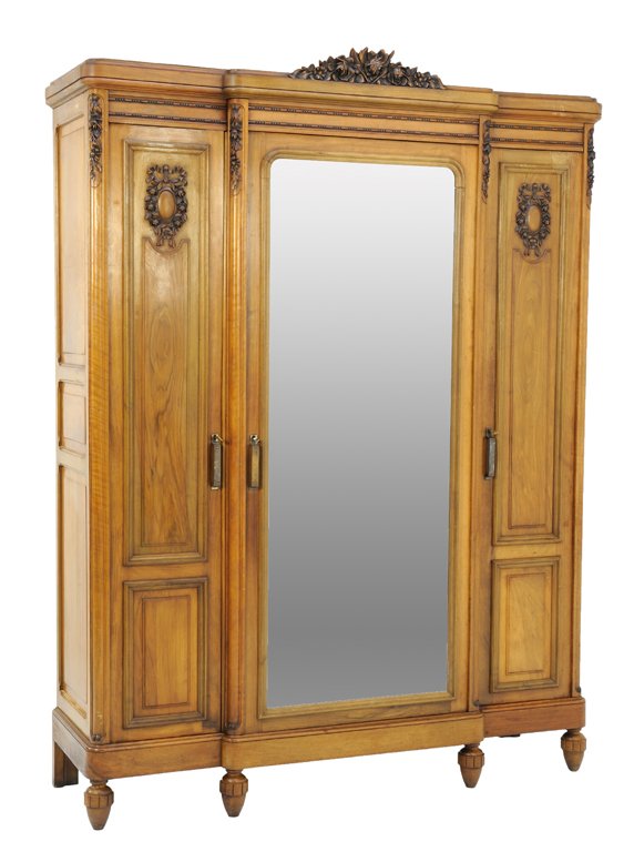 A LOUIS XVI STYLE OAK ARMOIRE WITH ROSE BUD DETAILS: A LOUIS XVI STYLE OAK ARMOIRE WITH ROSE BUD DETAILS Early 20th Century, France A Louis XVI style oak armoire with a rose bud festoon crown, a stepped frieze, a mirrored center door flanked by two pane