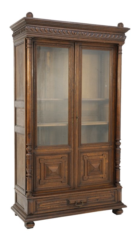 A HENRI II STYLE BOOKCASE: A HENRI II STYLE BOOKCASE Early 20th Century, France A Henri II style bookcase with stepped cornice, carved gadroon frize, having two glazed doors with lower diamond lozenge detail is flanked by turne