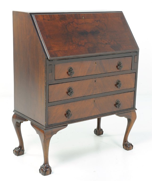 A VINTAGE FLIP TOP MAHOGANY FINISH DESK WITH CLAW AND B: A VINTAGE FLIP TOP MAHOGANY FINISH DESK WITH CLAW AND BALL FEET 20th Century The flip top opens to reveal cubbies and a center drawer and writing surface surmounting three locking drawers; raised on c