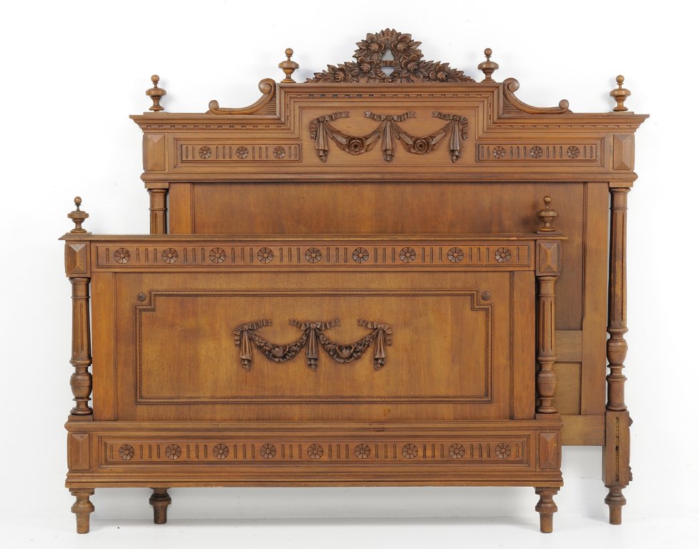 A NEOCLASSICAL STYLE WALNUT FINISH BED WITH BUD AND FES: A NEOCLASSICAL STYLE WALNUT FINISH BED WITH BUD AND FESTOON SWAG Early 20th Century, France A Neoclassical style bed is crowned by a carved wreath and finials, a carved swag and bud frieze, reed carve