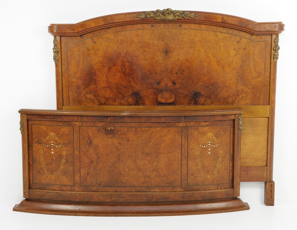 AN ART DECO STYLE BURLED WALNUT FINISH BED WITH MOTHER : AN ART DECO STYLE BURLED WALNUT FINISH BED WITH MOTHER OF PEARL INLAY AND SHIELD Early 20th Century An Art Deco style burled walnut finish bed with ormolu mounts, a burled veneer with inlaid tracery, 