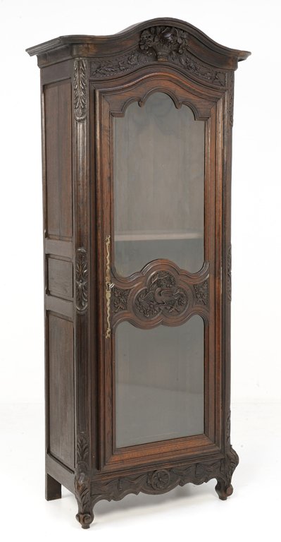 AN ANTIQUE LOUIS XV STYLE SHOWCASE WITH EAGLE: AN ANTIQUE LOUIS XV STYLE SHOWCASE WITH EAGLE Early 20th Century, France An antique Louis XV style showcase features a highly carved frieze with bud, a shaped single door with center trefoil and eagle