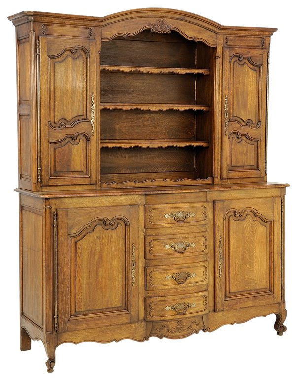 A LOUIS XV STYLE OAK BUFFET SIDEBOARD: A LOUIS XV STYLE OAK BUFFET SIDEBOARD Early 20th Century The arched cornice surmounts open shelving flanked by two locking doors highlighted by carved reserves supported by a lower oak body housing fo
