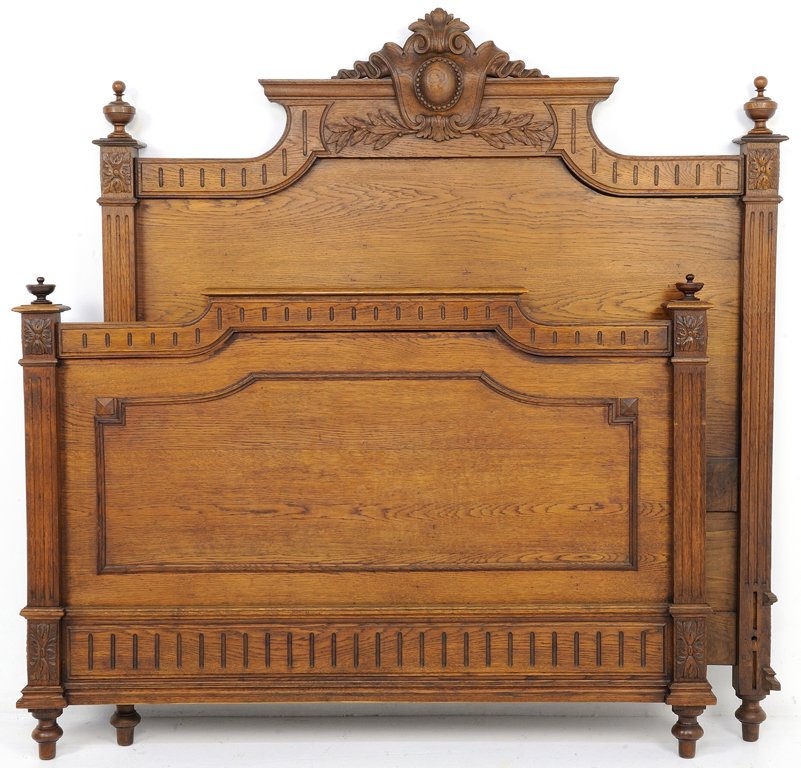AN ANTIQUE OAK HENRI II STYLE BED WITH MEDALLION AND FE: AN ANTIQUE OAK HENRI II STYLE BED WITH MEDALLION AND FESTOON Early 20th Century The reeded crest rail is highlighted by a scroll form motif flanked by finials. Raised on turned feet. Very good conditi