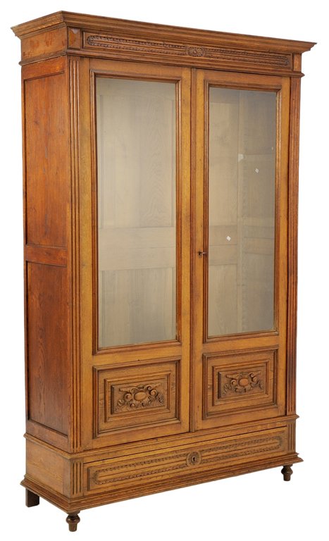 A LOUIS XV STYLE SCHOLAR'S OAK BOOKCASE: A LOUIS XV STYLE SCHOLAR'S OAK BOOKCASE Early 20th Century A rectilinear cornice supported by recessed, conforming body with two locking glass doors with carved reserves surmounting a locking base dra