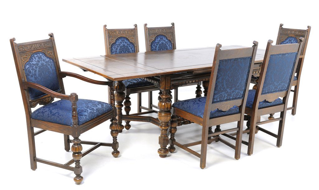 A JACOBEAN STYLE TABLE, FIVE CHAIRS, AND ARM CHAIR WITH: A JACOBEAN STYLE TABLE, FIVE CHAIRS, AND ARM CHAIR WITH BLUE DAMASK UPHOLSTERY Early-Mid 20th Century A fine draw leaf Jacobean style table features dental carved apron, cup and cover uprights, an ""X
