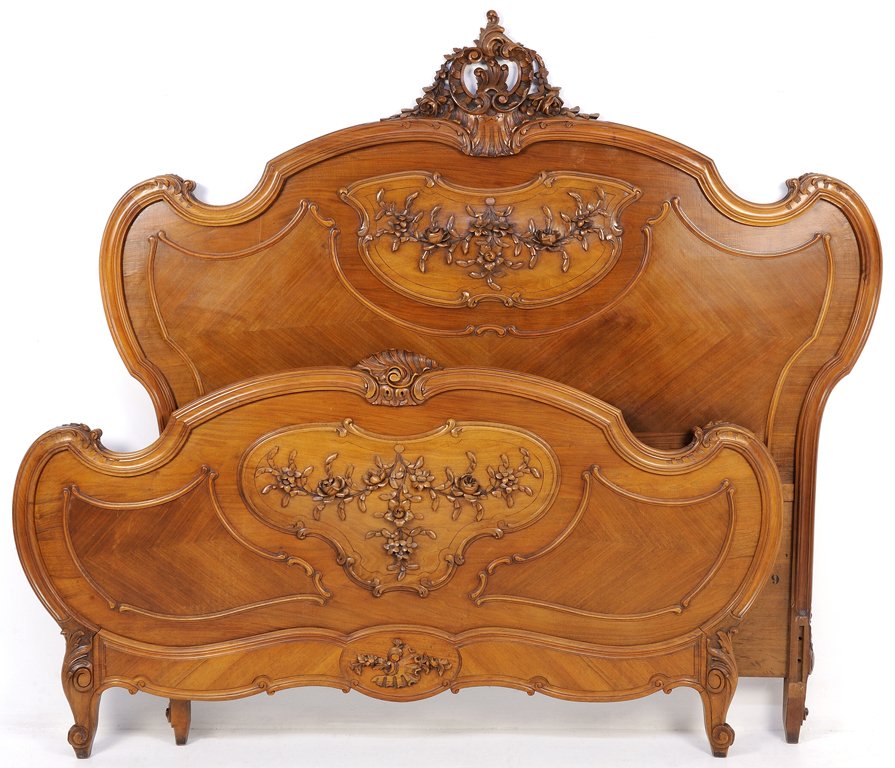 A LOUIS XV STYLE WALNUT BED WITH BUDS AND FESTOONS: A LOUIS XV STYLE WALNUT BED WITH BUDS AND FESTOONS Early 20th Century, France A Louis XV style walnut bed features a pierced carved acanthus crown, carved tracery, bud festoons on kidney shaped medall