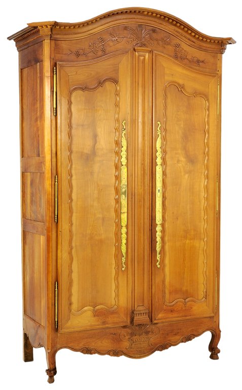 AN ANTIQUE LOUIS XV STYLE OAK ARMOIRE WITH CARVED WHEAT: AN ANTIQUE LOUIS XV STYLE OAK ARMOIRE WITH CARVED WHEAT AND GRAPES Early 20th Century The armoire with arched cornice highlighted by carved wheat and grape foliate details surmounting two locking door