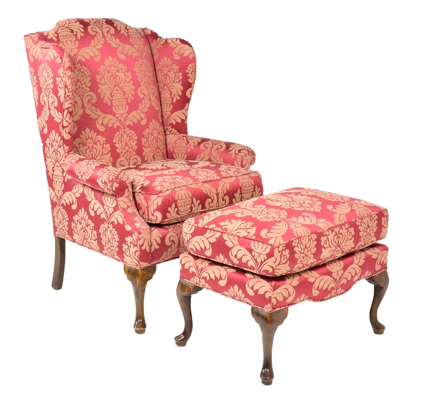 AN ANTIQUE RED DAMASK WINGBACK ARMCHAIR AND OTTOMAN: AN ANTIQUE RED DAMASK WINGBACK ARMCHAIR AND OTTOMAN Early 20th Century An antique red damask covered wingback armchair feautres a shaped top, with flanking covered wings; raised on cabriole legs with 