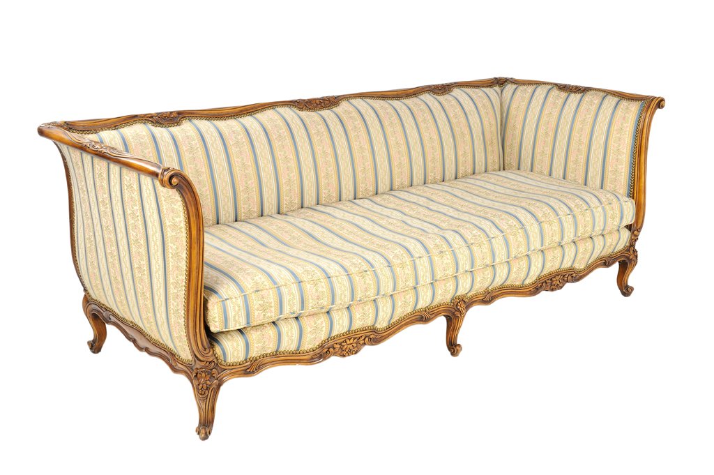 A PROVENCIAL VICTORIAN STYLE CARVED SLEIGH SOFA: A PROVENCIAL VICTORIAN STYLE CARVED SLEIGH SOFA Early - Mid 20th Century A Victorian style sleigh sofa features heavily carved show wood with provencial flower details, having pink and blue striped fl