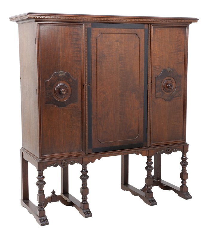 AN ENGLISH STYLE OAK CUPBOARD CABINET WITH THREE DOORS: AN ENGLISH STYLE OAK CUPBOARD CABINET WITH THREE DOORS Early-Mid 20th Century An English style cupboard features a carved dental edge, three cabinet doors with center having inlaid ebonized wood frame