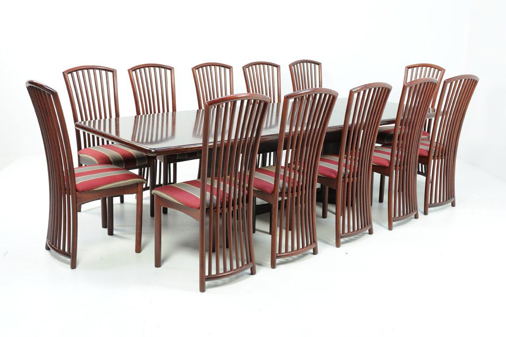A MAHOGANY DINING TABLE AND TWELVE REED STYLE SIDE: A MAHOGANY DINING TABLE AND TWELVE REED STYLE SIDE CHAIRS 20th Century The mahogany dining table with two leaves includes twelve mahogany side chairs upholstered in a striped fabric. Good condition, m