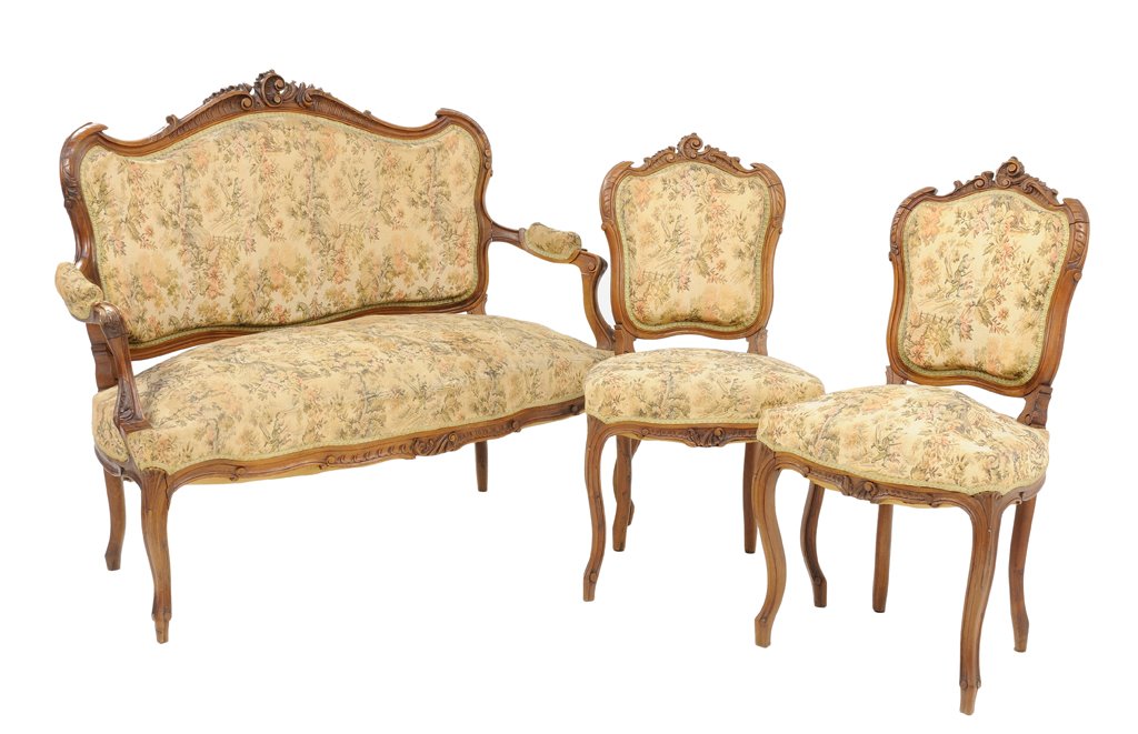 A THREE PIECE WALNUT FINISH ROCOCO REVIVAL STYLE: A THREE PIECE WALNUT FINISH ROCOCO REVIVAL STYLE PARLOUR SET France, Early 20th Century A Rococo style parlour set includes a settee with carved scrolling crest rail with antique embroidered tapestry 