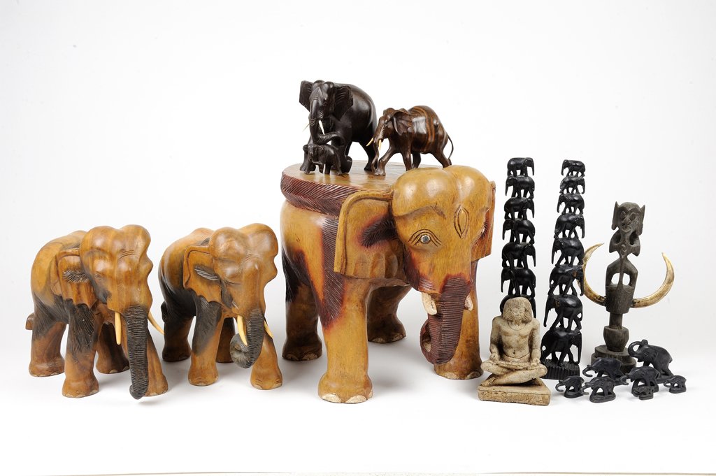 AN ELEPHANT DECOR GROUPING INCLUDES CARVED STOOL: AN ELEPHANT DECOR GROUPING INCLUDES CARVED STOOL 20th Century An elephant decor grouping includes elephant totems, small soap stone sculptures, carved elephants with bone tusk details, an elephant sha
