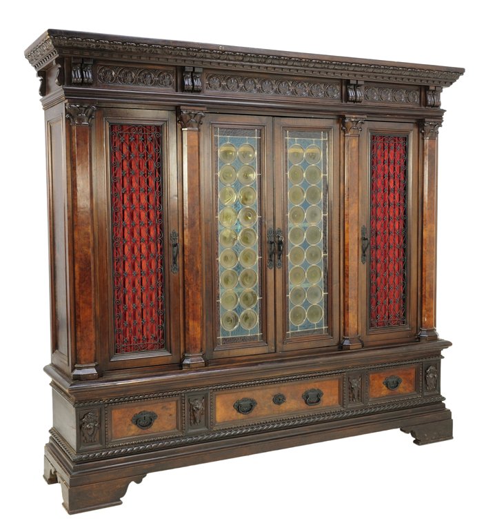 AN ITALIAN RENAISSANCE REVIVAL STYLE WALNUT BOOKCASE: AN ITALIAN RENAISSANCE REVIVAL STYLE WALNUT BOOKCASE WITH STAINED GLASS AND COW SKULLS Early 20th Century An Italian Renaissance Revival style walnut bookcase features a carved stepped cornice, Corint