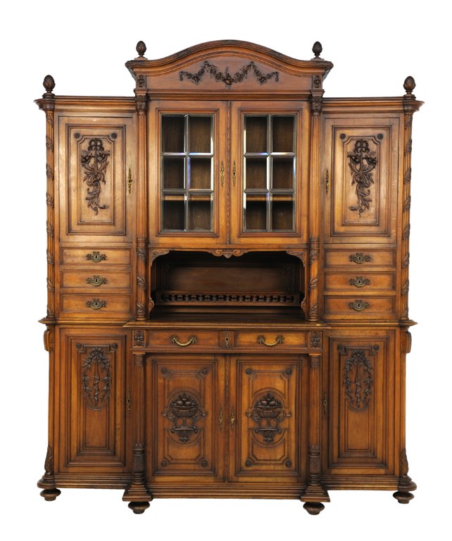 A LOUIS XVI STYLE BUFFET: A LOUIS XVI STYLE BUFFET Early-Mid 20th Century A Louis XVI style buffet features a camel back cornice with flanking finial details with a carved festoon swag frieze with glazed center display flanked