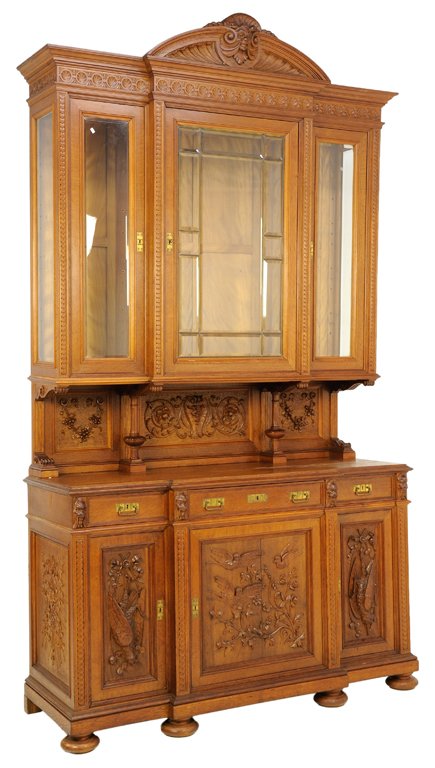 A GERMAN BLACK FOREST STYLE CARVED OAK BUFFET WITH FOWL: A GERMAN BLACK FOREST STYLE CARVED OAK BUFFET WITH FOWL Early 20th Century A German Black Forest style carved oak buffet with serpentine cornice with carved foliate medallion at center, having three g