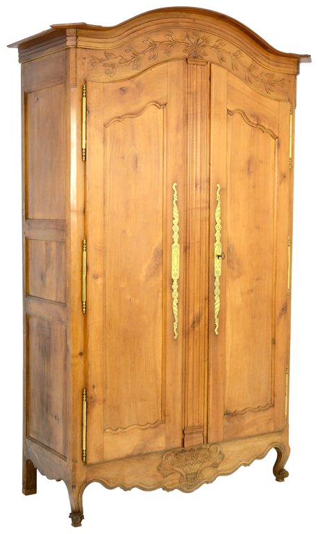 A PROVINCIAL LOUIS XV STYLE WALNUT FINISH ARMOIRE WITH: A PROVINCIAL LOUIS XV STYLE WALNUT FINISH ARMOIRE WITH CARVED WHEAT Late 19th-Early 20th Century With gilt brass escutcheon. Minor exposure to woodworm. Overall in very good condition, wear commensura
