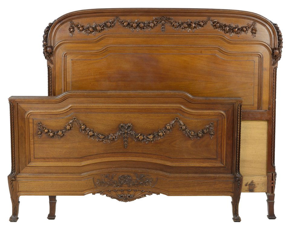 ANTIQUE HAND CARVED FRENCH WALNUT BED: ANTIQUE HAND CARVED FRENCH WALNUT BED Early 20th century French bed in a transitional Art Nouveau style, featuring a softly arched headboard with carved floral festoon embellishment at each corner and